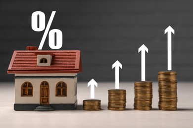 Mortgage rate. Model of house, stacked coins, arrows and percent sign