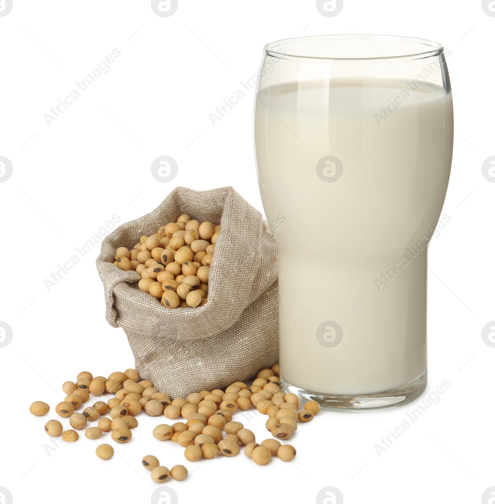 Photo of Glass of fresh soy milk and sack bag with beans on white background