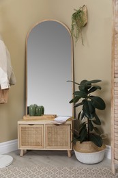 Stylish hallway room interior with wooden commode and large mirror