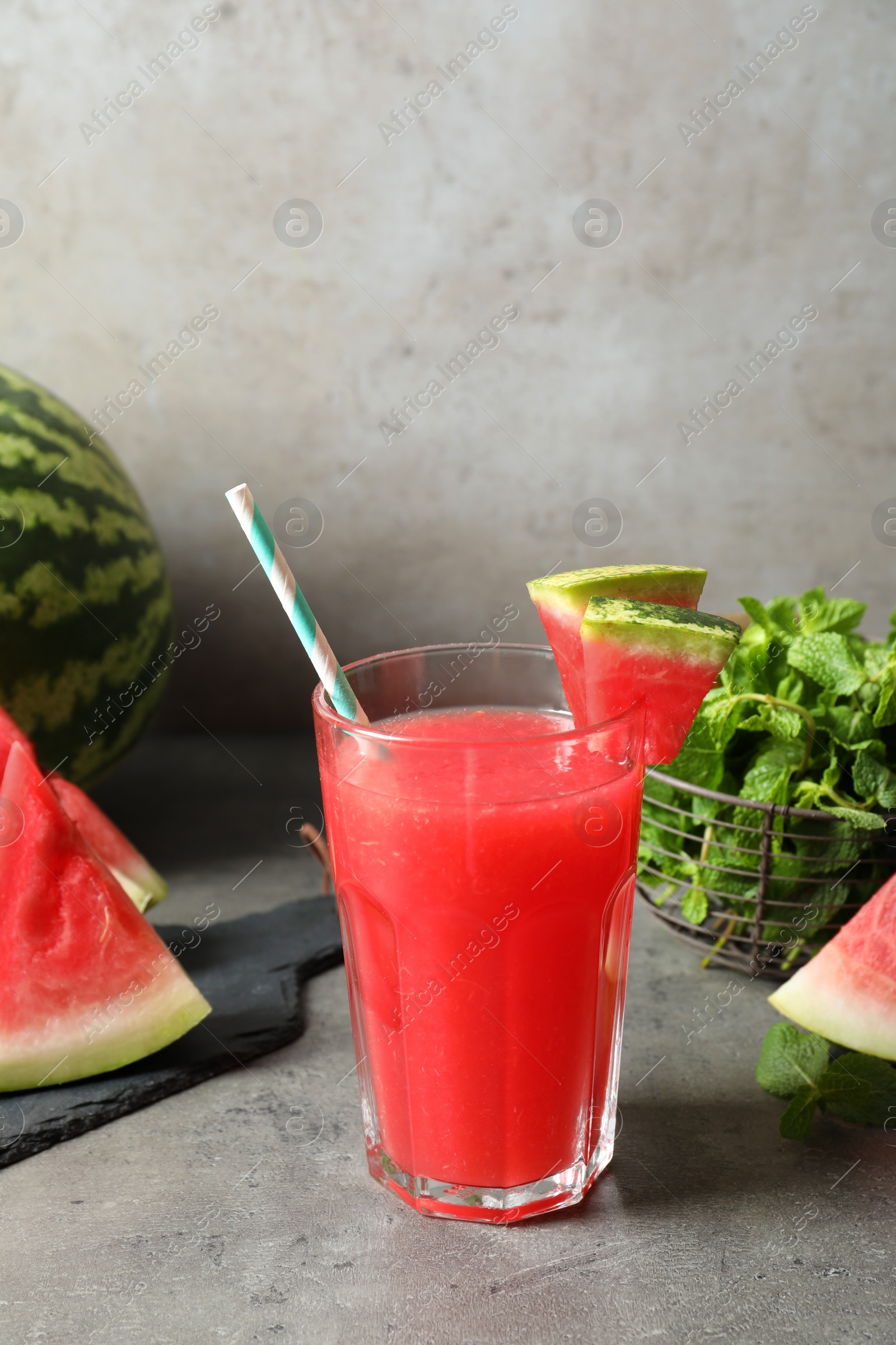 Photo of Summer watermelon drink in glass and sliced fruit on table