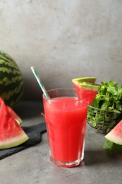 Photo of Summer watermelon drink in glass and sliced fruit on table