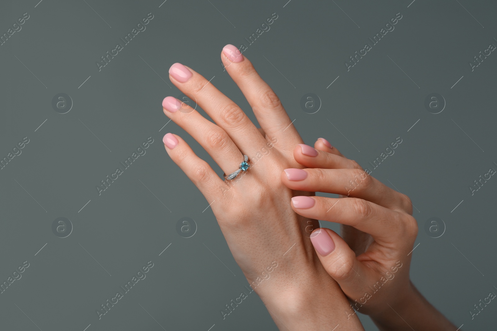 Photo of Woman with elegant ring on dark grey background, closeup