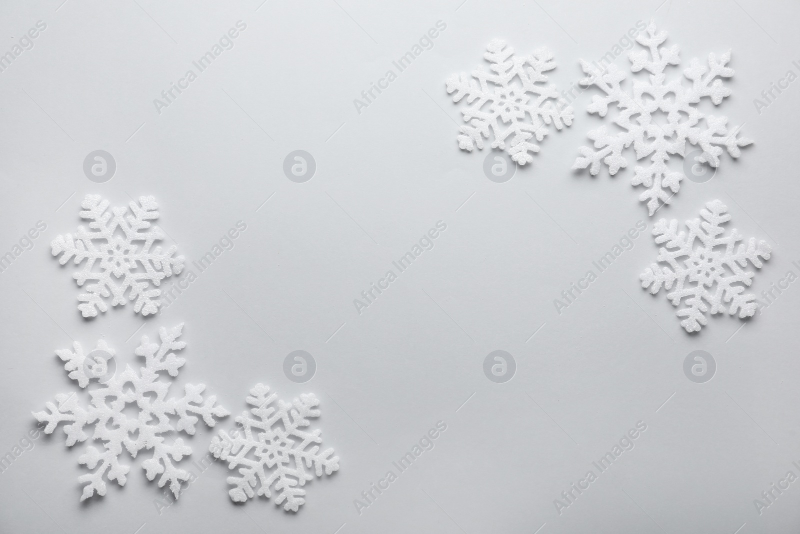 Photo of Beautiful snowflakes on white background, flat lay. Space for text