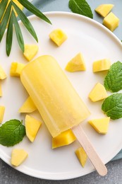 Photo of Plate of tasty mango ice pop on table, flat lay. Fruit popsicle