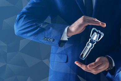 Man demonstrating dental implant on light blue background, closeup