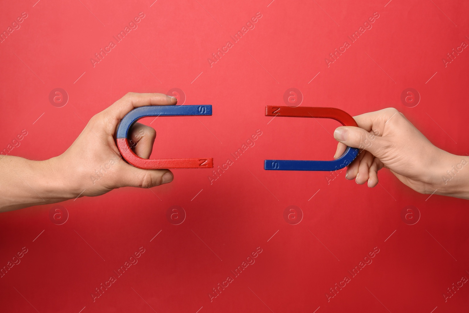 Photo of People holding magnets on color background, closeup