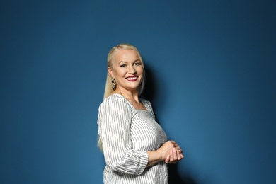 Portrait of beautiful mature woman on blue background