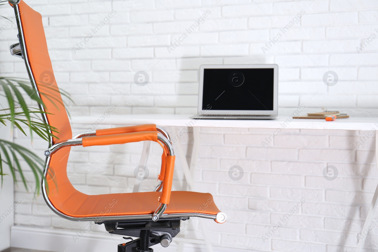 Photo of Comfortable workplace with office chair and wooden table