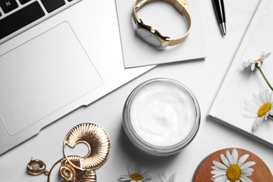 Photo of Flat lay composition with jar of hand cream and chamomiles on white table
