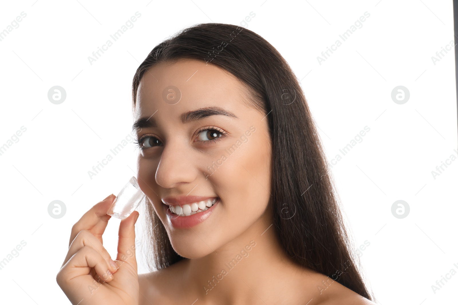 Photo of Young woman with ice cube on white background. Skin care