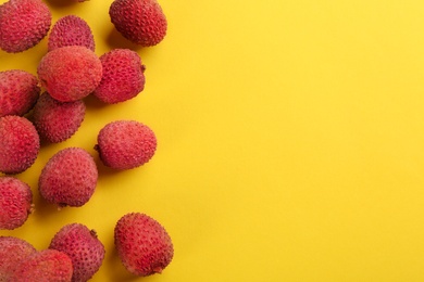Fresh ripe lychees on yellow background, flat lay. Space for text