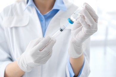 Photo of Female doctor with vial and syringe in hospital. Vaccination day