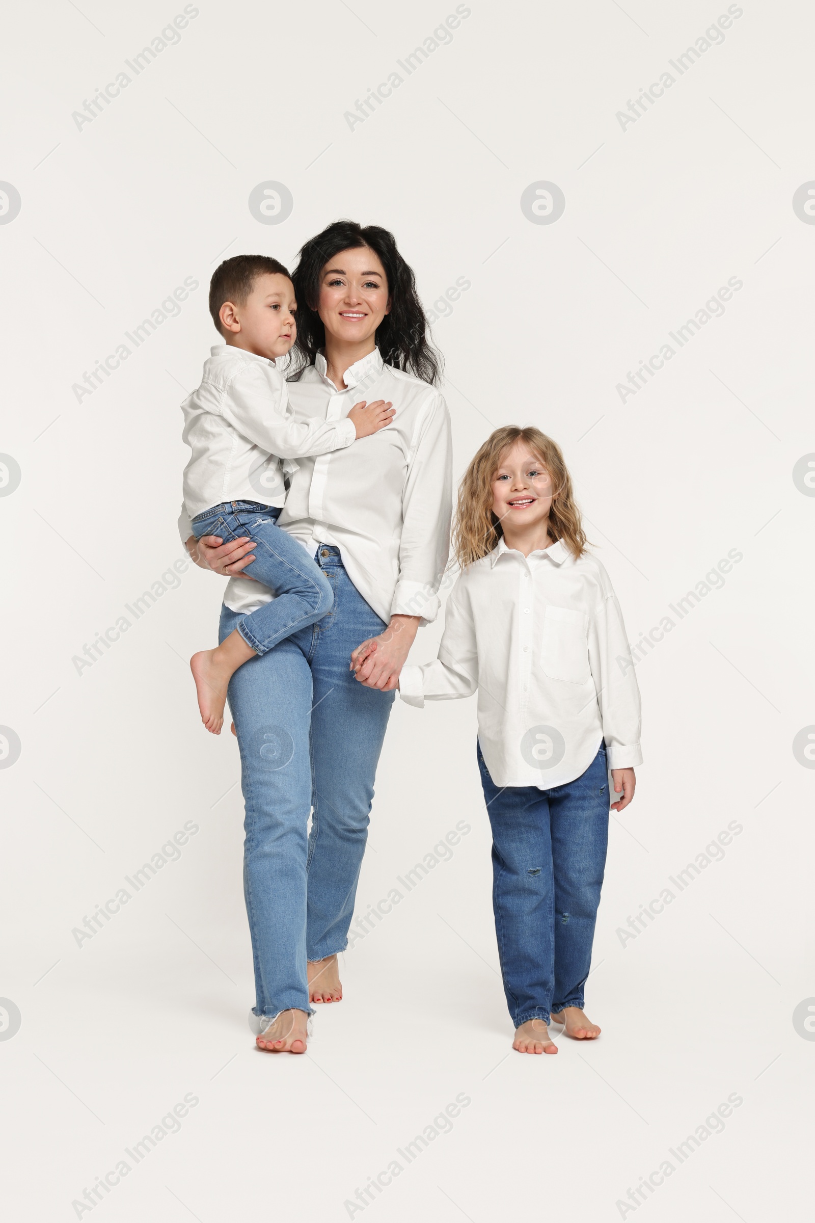 Photo of Little children with their mother on white background