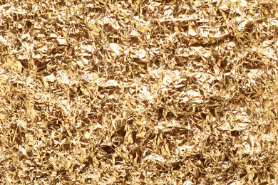 Crumpled gold foil as background, top view