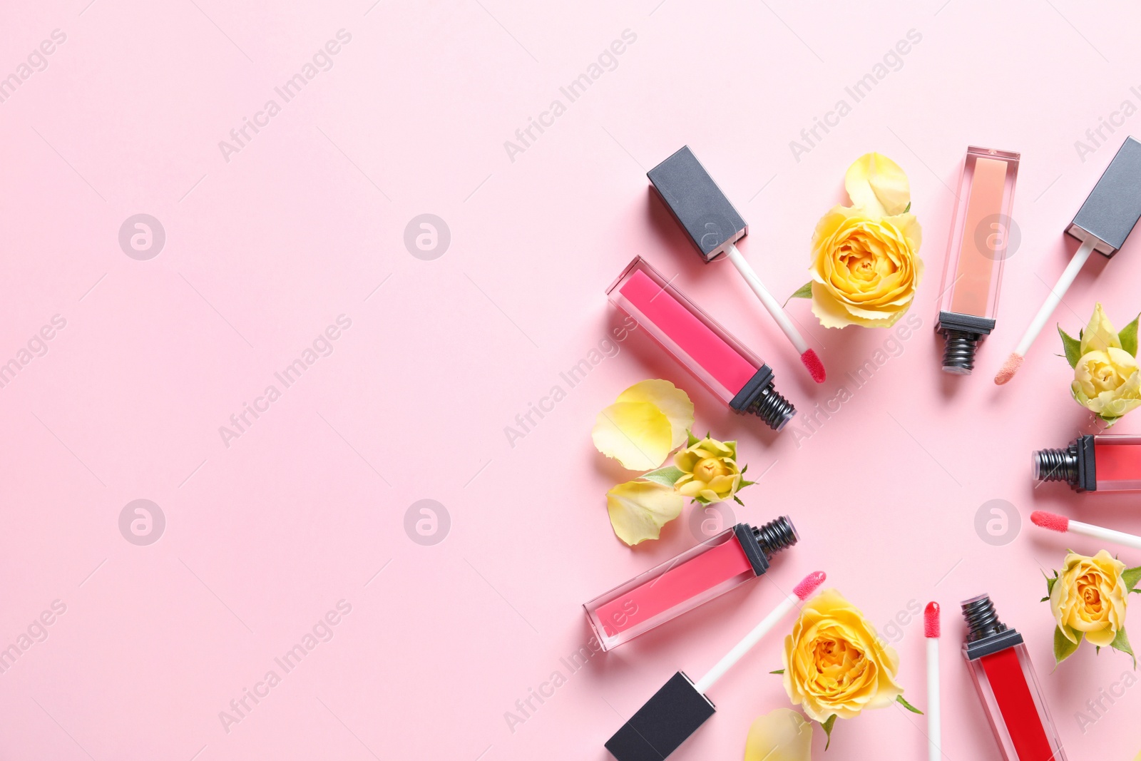 Photo of Composition of lipsticks with flowers on color background, flat lay. Space for text.