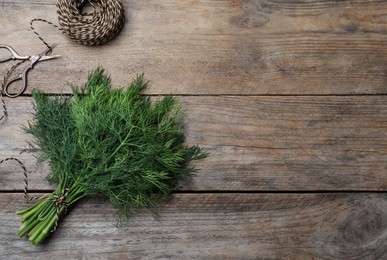 Photo of Fresh dill and twine on wooden table, flat lay. space for text