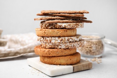 Photo of Stack of rye crispbreads, rice cakes and rusks on white table