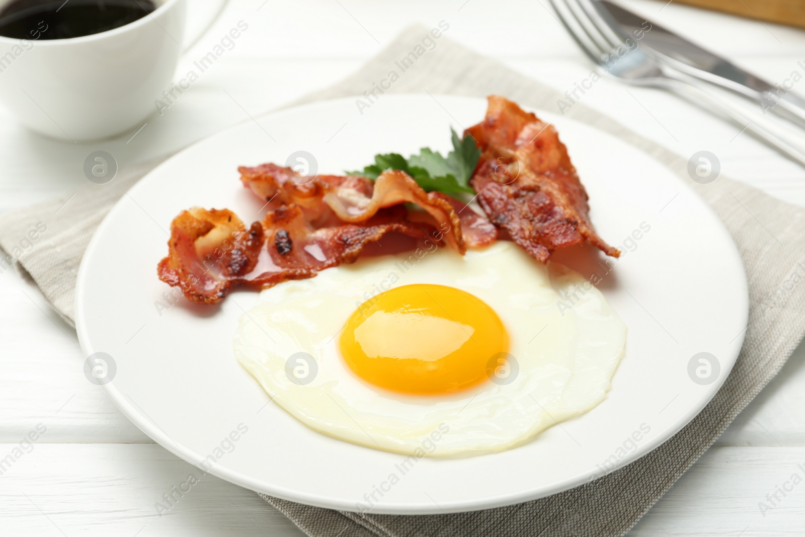 Photo of Delicious breakfast with sunny side up egg on white wooden table, closeup