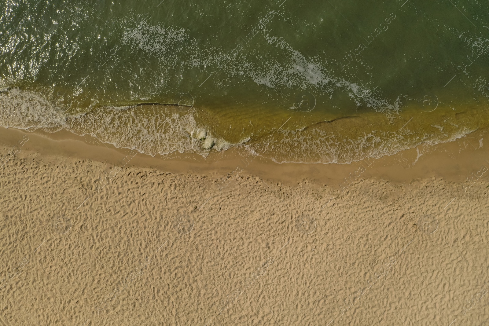 Photo of Sea waves rolling on beautiful sandy beach, aerial top view. Summer vacation