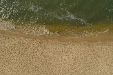 Sea waves rolling on beautiful sandy beach, aerial top view. Summer vacation