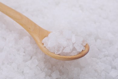 Photo of Wooden spoon with white sea salt, closeup