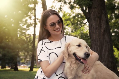 Young woman with her golden retriever dog in park