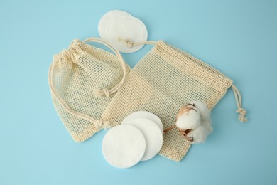 Photo of Bags, cotton pads and flower on light blue background