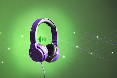 Modern headphones with illustration of dynamic sound waves on green background