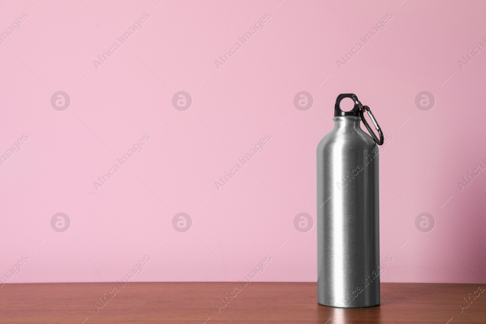 Photo of Aluminum water bottle for sports on color background. Space for text