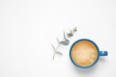 Photo of Coffee in cup and eucalyptus on white background, top view. Color of the year 2020 (Classic blue)