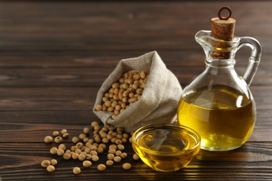 Photo of Composition with soybean oil on wooden table, space for text