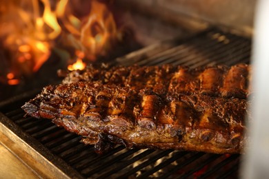 Photo of Grilling grate with tasty pork ribs in oven, closeup