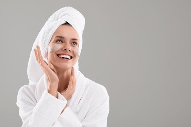 Photo of Woman with cosmetic product on her face against grey background, space for text. Spa treatments