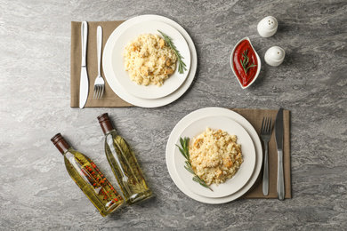 Photo of Delicious chicken risotto served on grey table, flat lay
