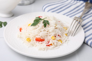 Photo of Delicious rice with vegetables and parsley served on table, closeup