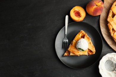 Photo of Slice of delicious peach pie with ice cream on black table, flat lay. Space for text