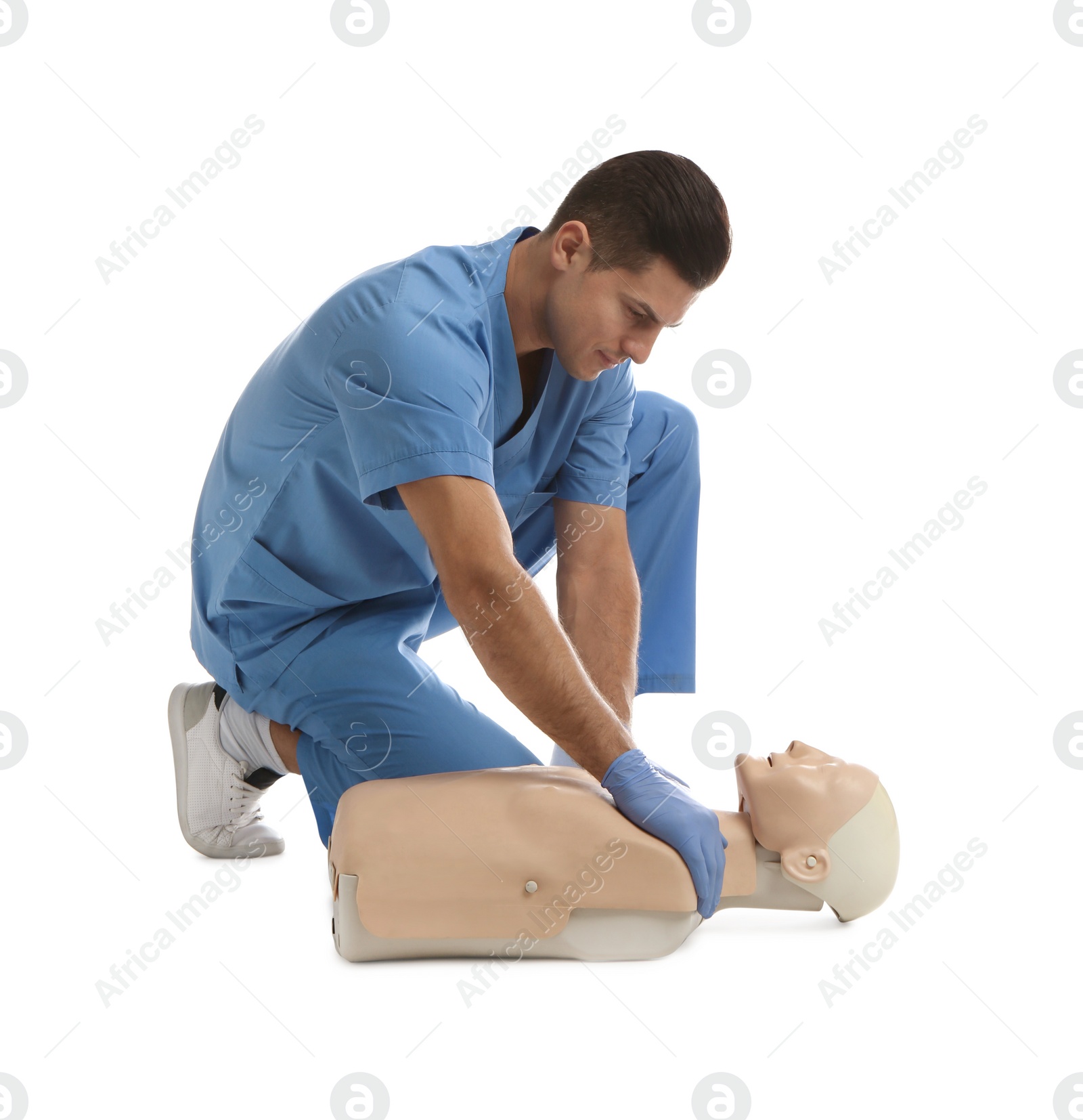 Photo of Doctor in uniform practicing first aid on mannequin against white background