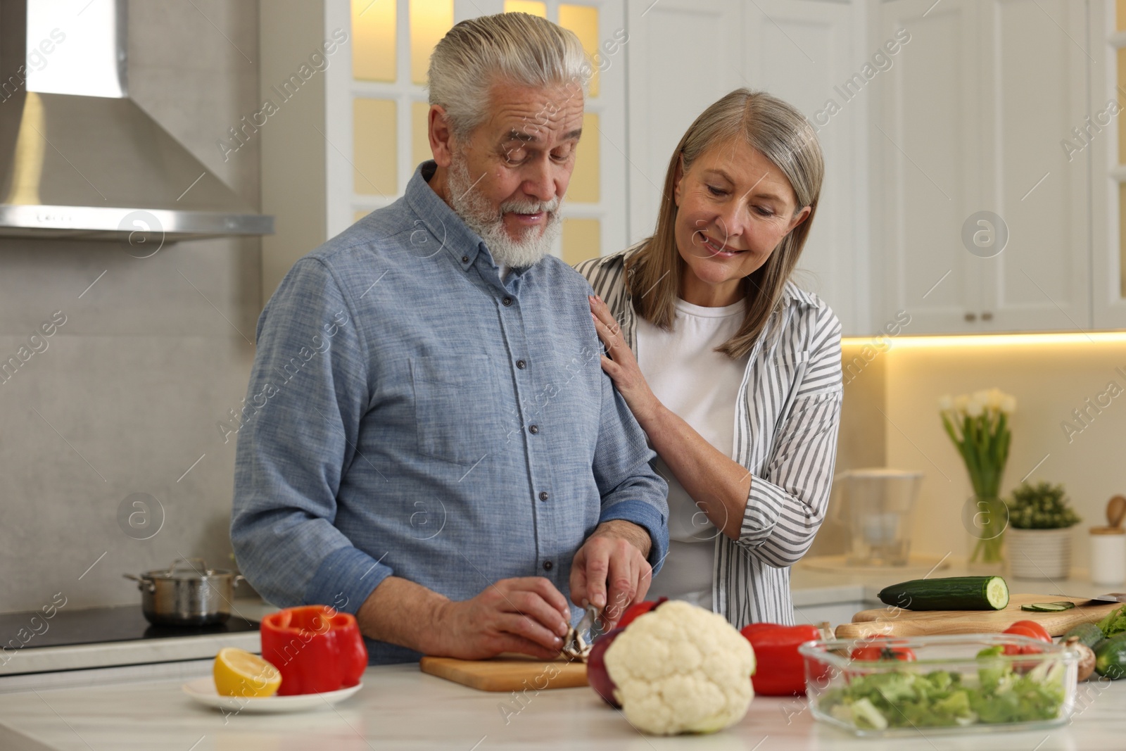 Photo of Happy senior couple cooking together in kitchen