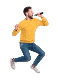 Handsome man with microphone singing and jumping on white background