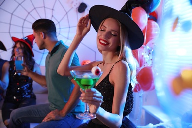 Woman holding cocktail with jelly eyeballs at Halloween party