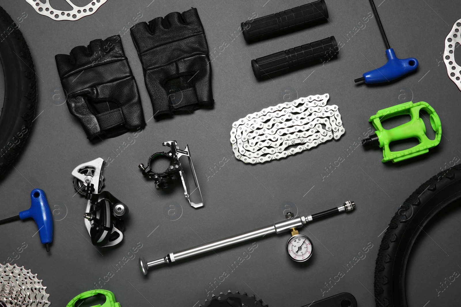 Photo of Set of different bicycle tools and parts on grey background, flat lay