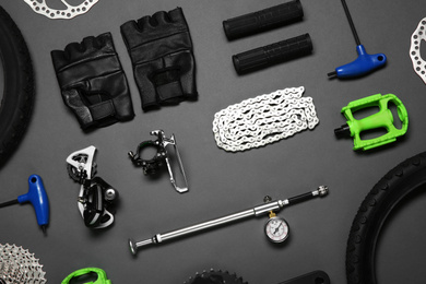 Photo of Set of different bicycle tools and parts on grey background, flat lay
