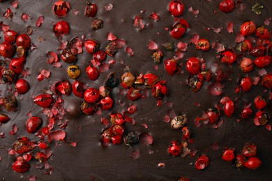 Texture of delicious chocolate bar with red peppercorns as background, top view