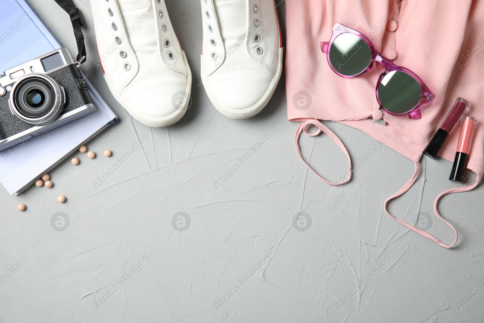 Photo of Flat lay composition with clothes and camera on light background, space for text. Fashion blogger