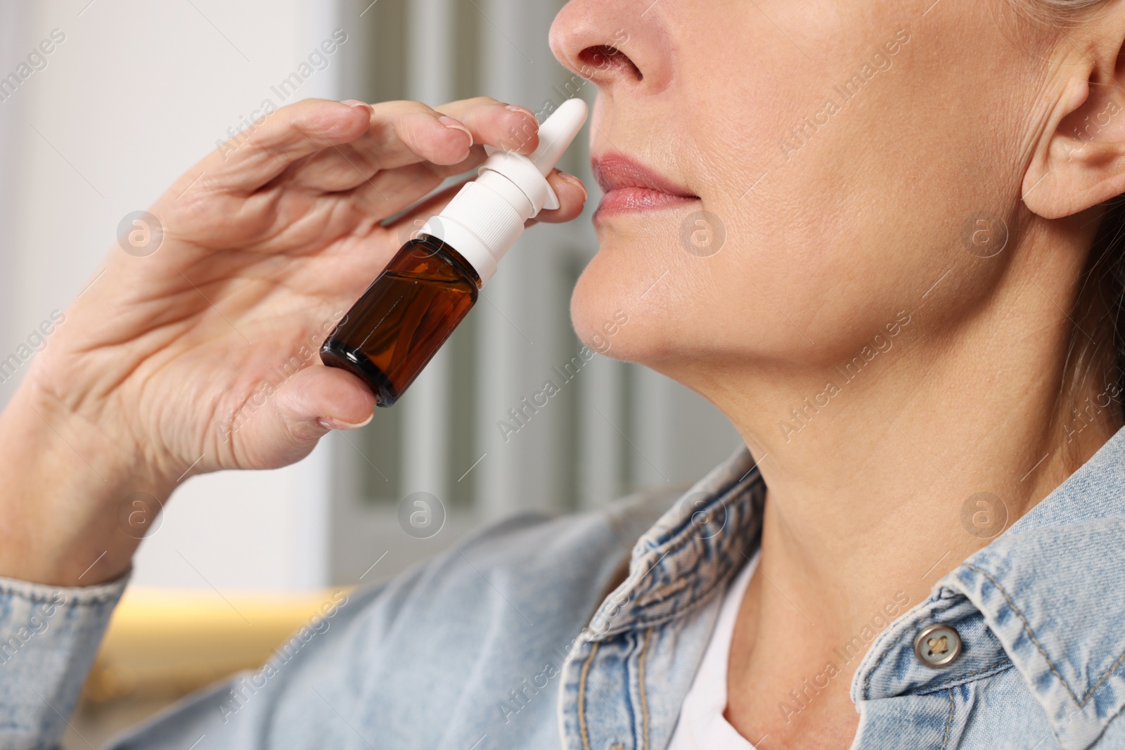 Photo of Medical drops. Woman using nasal spray indoors, closeup