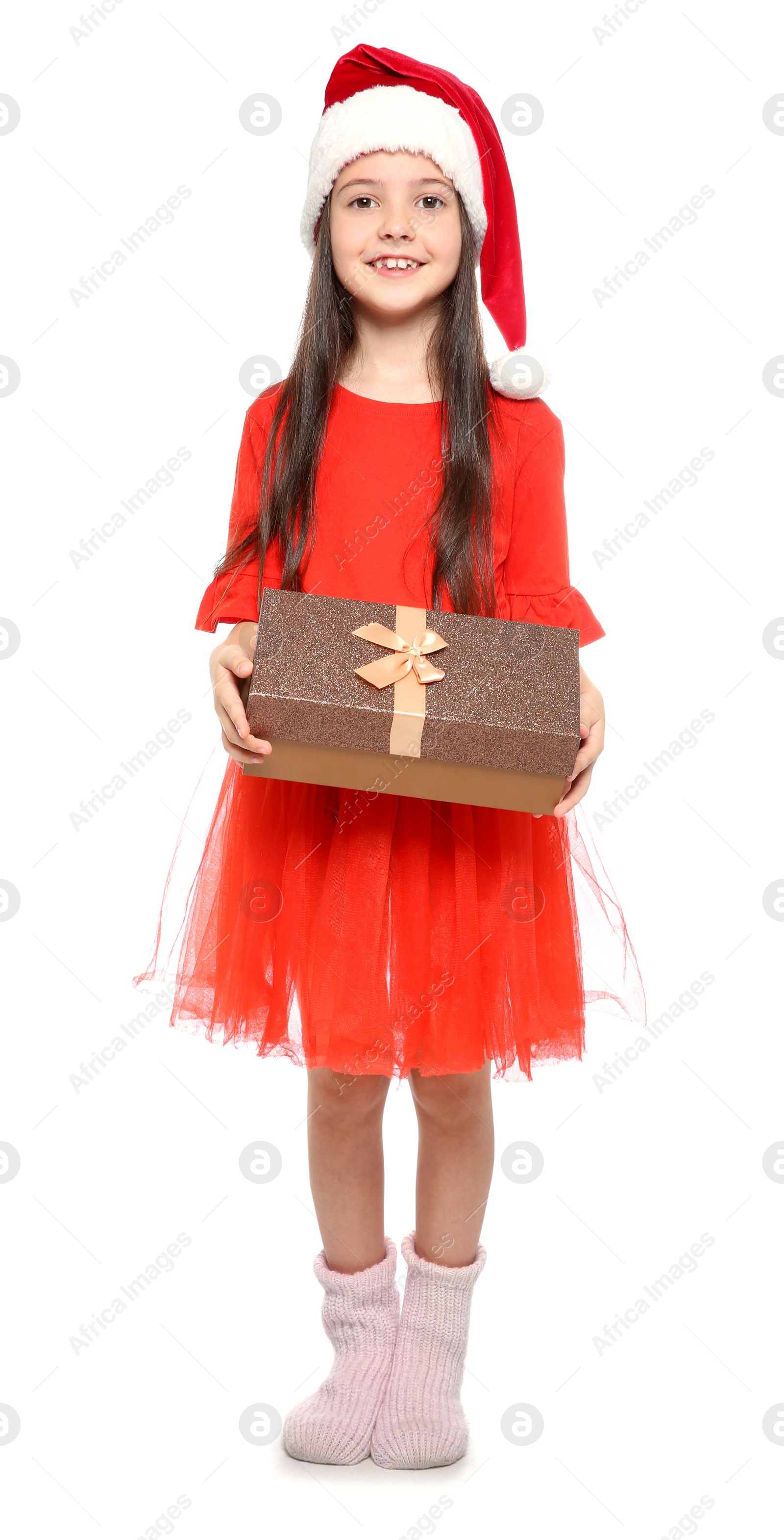 Photo of Cute little child in Santa hat with Christmas gift box on white background