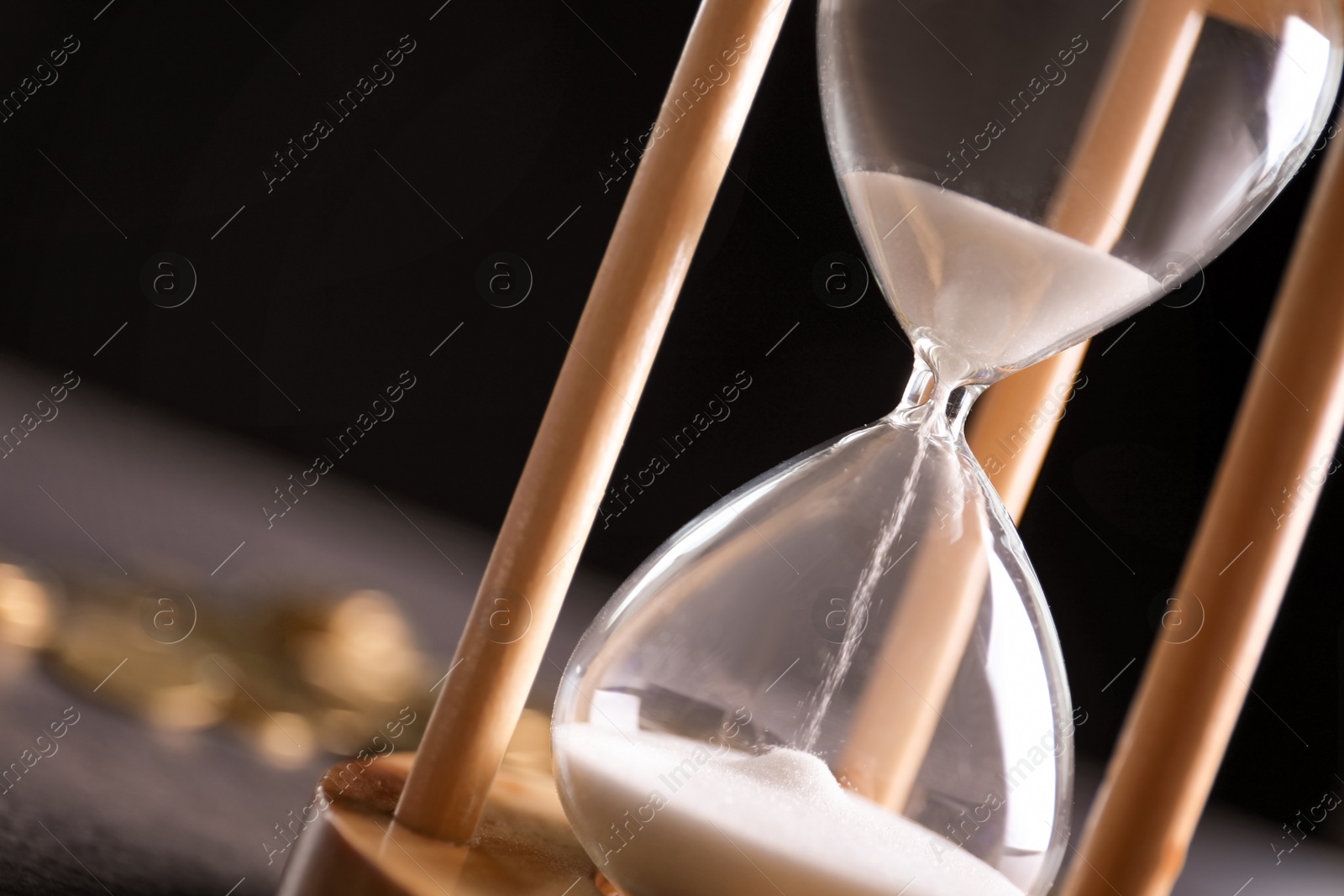 Photo of Hourglass with flowing sand on table, closeup. Time management