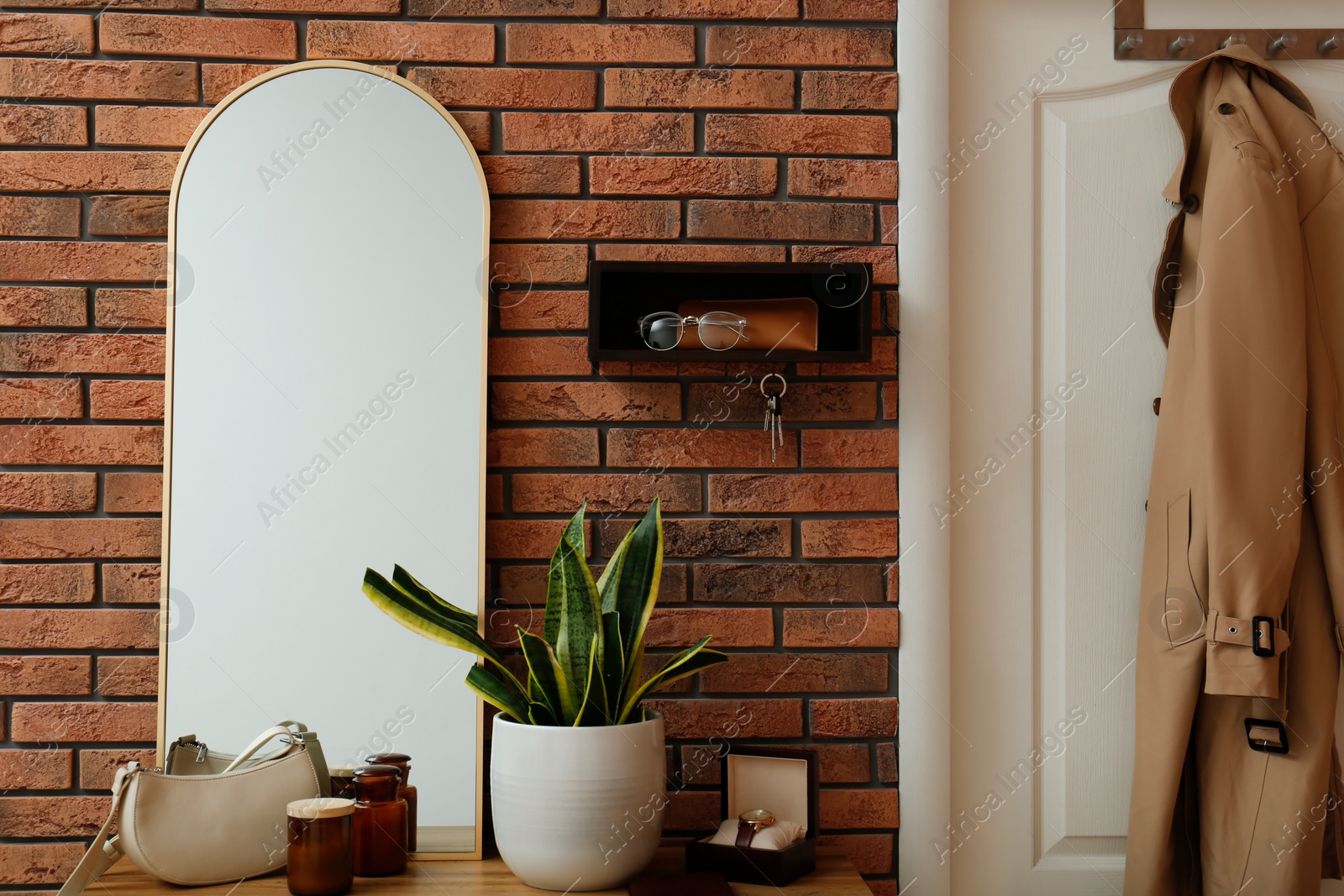 Photo of Stylish hanger for keys on brick wall in hallway