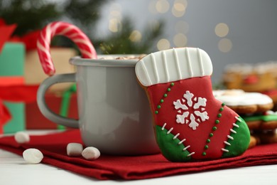 Tasty homemade Christmas cookie and hot drink on white table, closeup