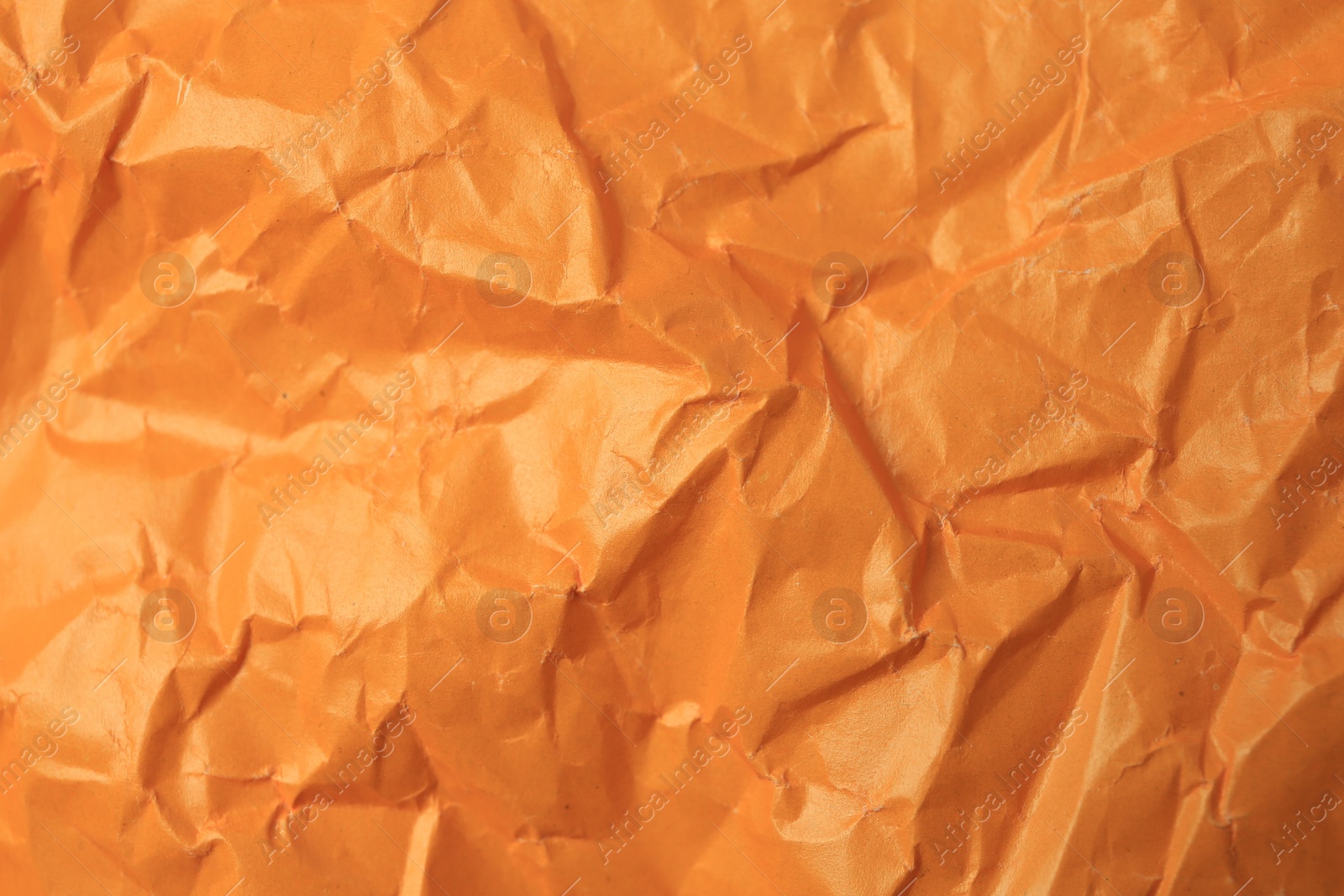 Photo of Sheet of crumpled orange paper as background, top view